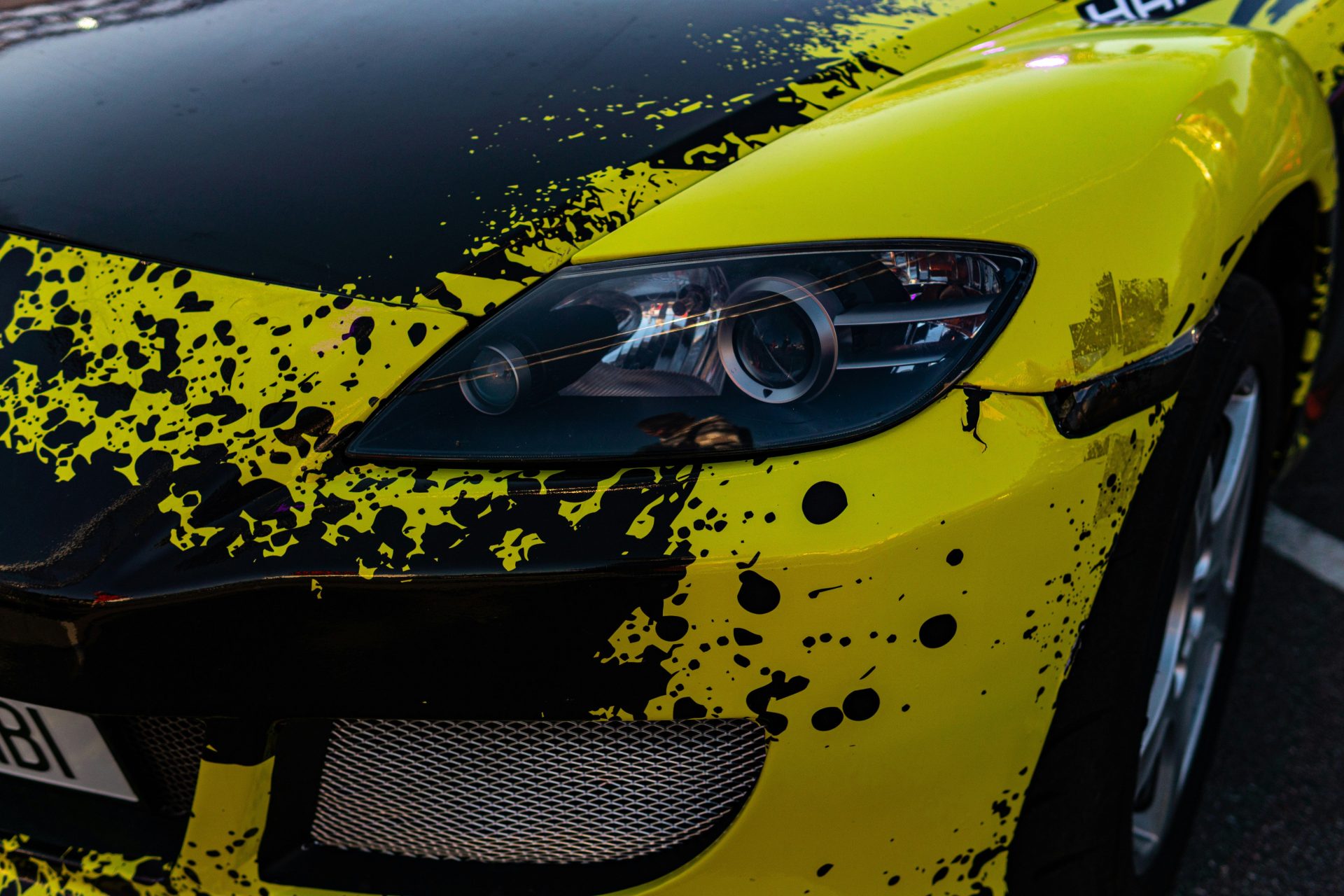 Customized yellow car with black paint splatters