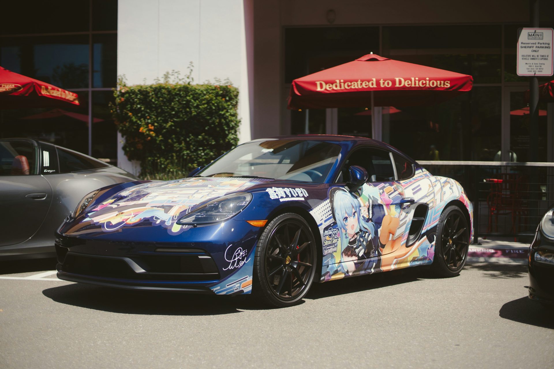 A blue car is parked near a restaurant
