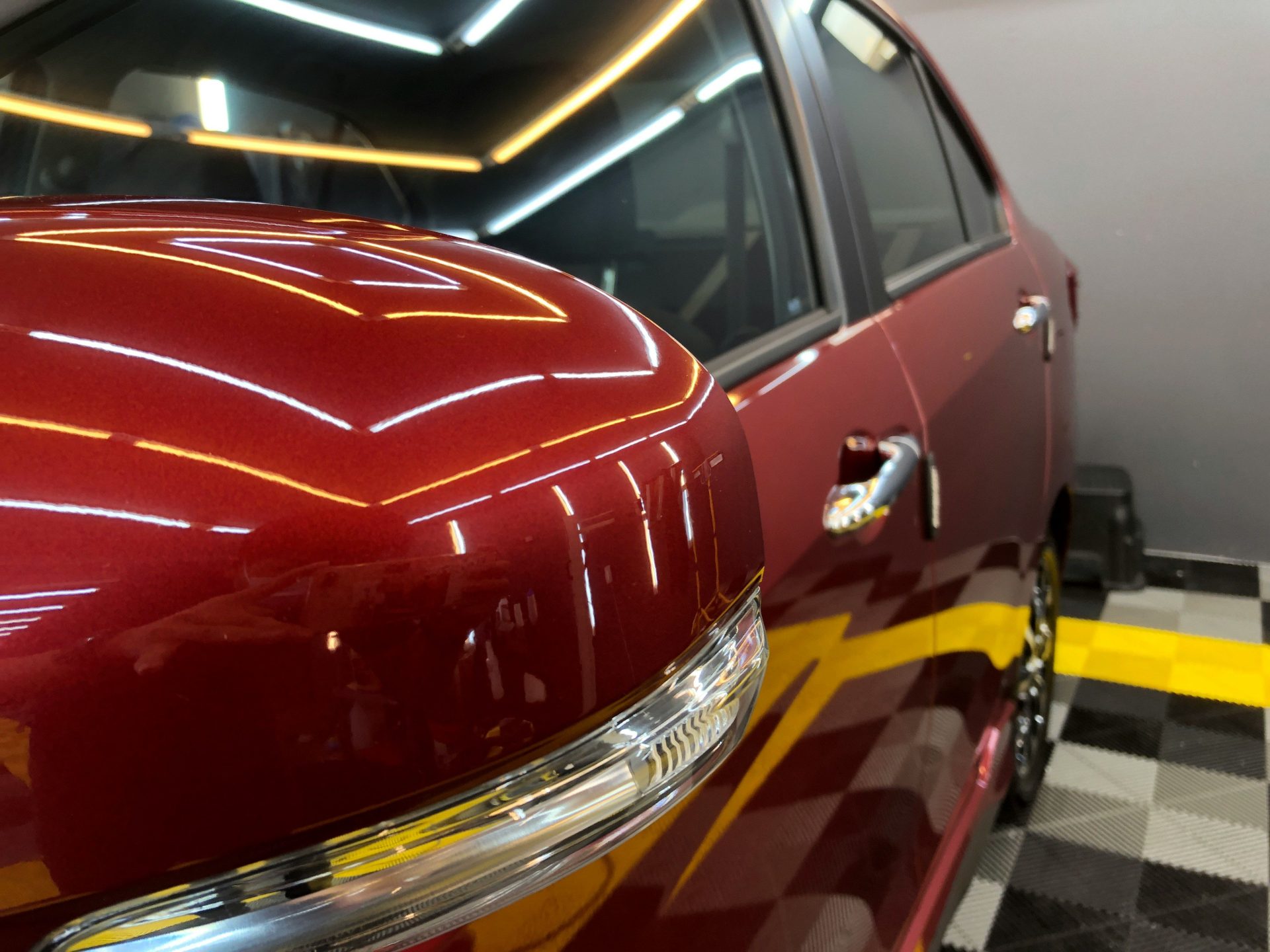 a red car parked in a garage with a checkered floor